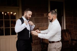 Groomsmen sharing a celebratory moment in formal attire at wedding reception.