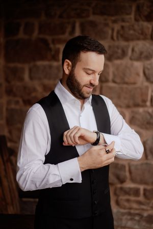 Close-up shots of a groom adjusting his cufflinks while getting ready for the ceremony.