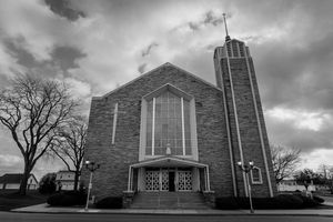 Dramatic black and white panoramic views of a modern stone church exterior.