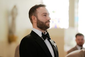 Formal wedding ceremony setup inside bright church sanctuary with wooden pews.