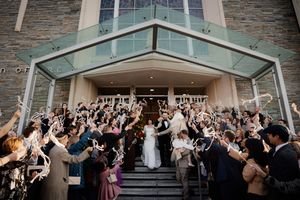 A panoramic view of wedding guests celebrating in a modern venue with stone walls.