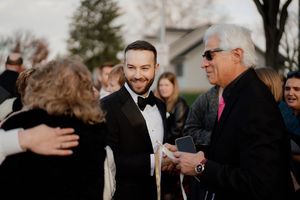 Wedding guests sharing warm embraces during an outdoor gathering.