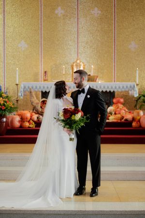 Church altar decorated with fall pumpkins and autumn decor for a wedding ceremony.