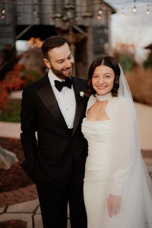 Elegant wedding couple sharing an intimate moment in formal black and white attire.