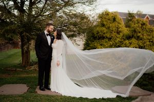 Elegant wedding photos with flowing veil captured in an outdoor garden setting.