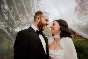 Couple sharing joyful moments during sunset wedding photoshoot.