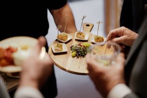 Close-up shots of wedding guests enjoying appetizers and drinks at reception.