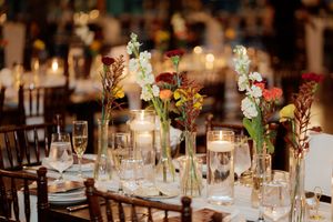 Elegant wedding reception table settings with delicate floral centerpieces and candlelight.