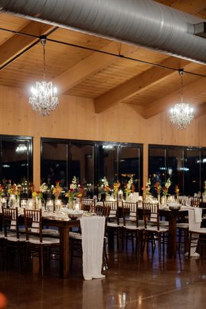 Elegant wedding reception hall with crystal chandeliers and tables set for dining.