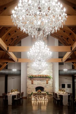 Elegant reception venue with crystal chandeliers and exposed wooden beams.