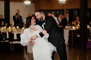 Couples dancing in an elegant ballroom with dark wood floors and ambient lighting.