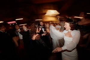 People dancing together in a dimly lit ballroom with warm lighting and romantic atmosphere.