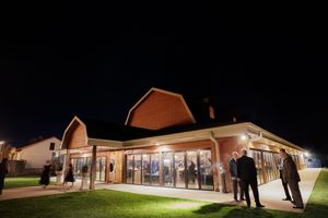 Illuminated barn venue glows warmly against the dark night sky during a wedding celebration.