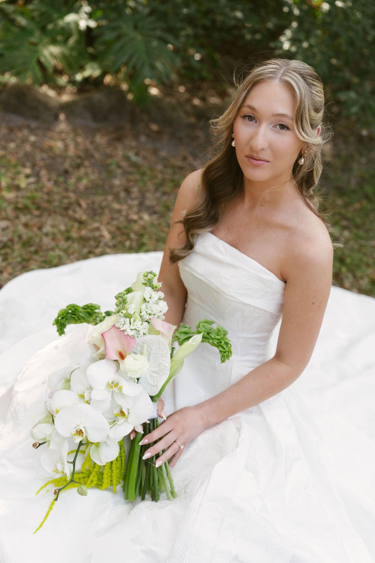 A series of intimate getting ready moments at a wedding showing the bride in a white dress being helped by others.