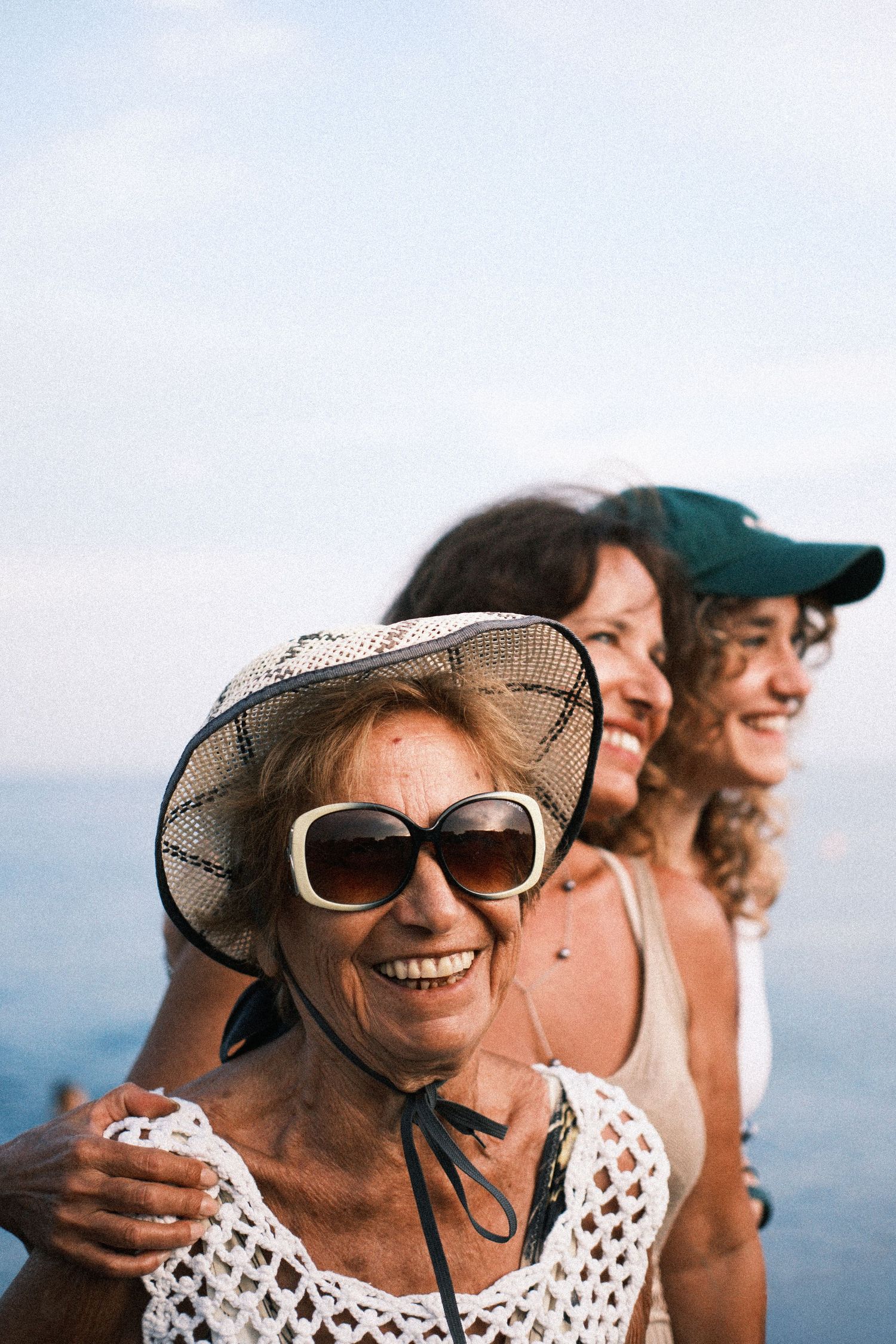 A group of people enjoying a sunny day outdoors wearing sunglasses and casual summer attire.