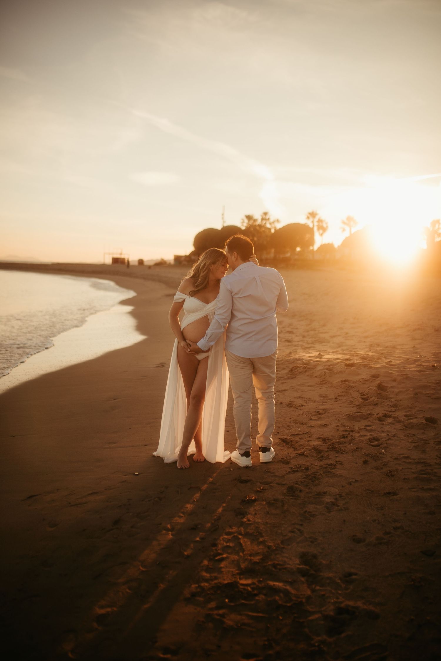 Pareja esperando un bebé al atardecer en la playa de Cambrils