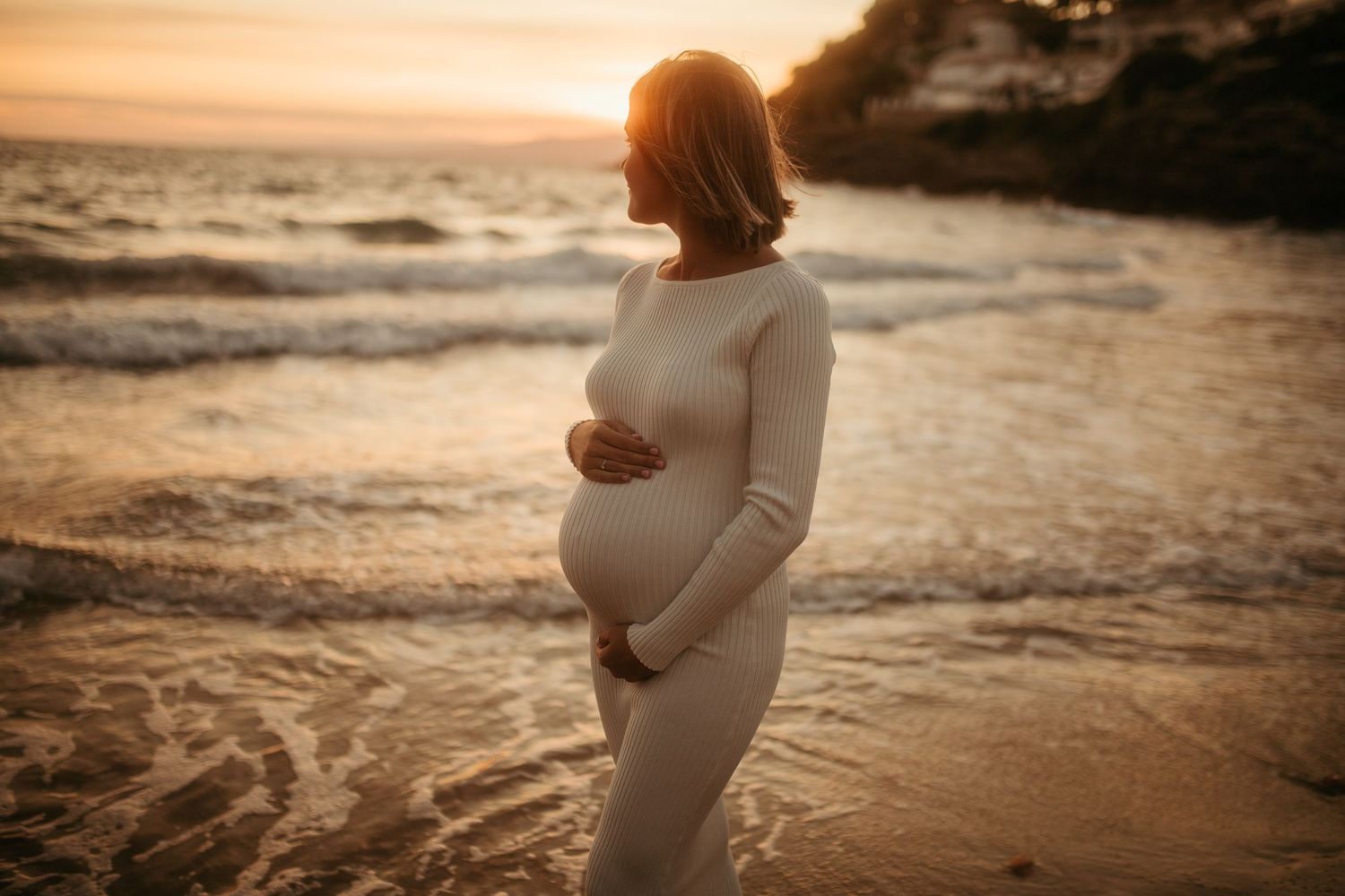 Futura madre mirando al mar en sesión de embarazo en Vila-seca