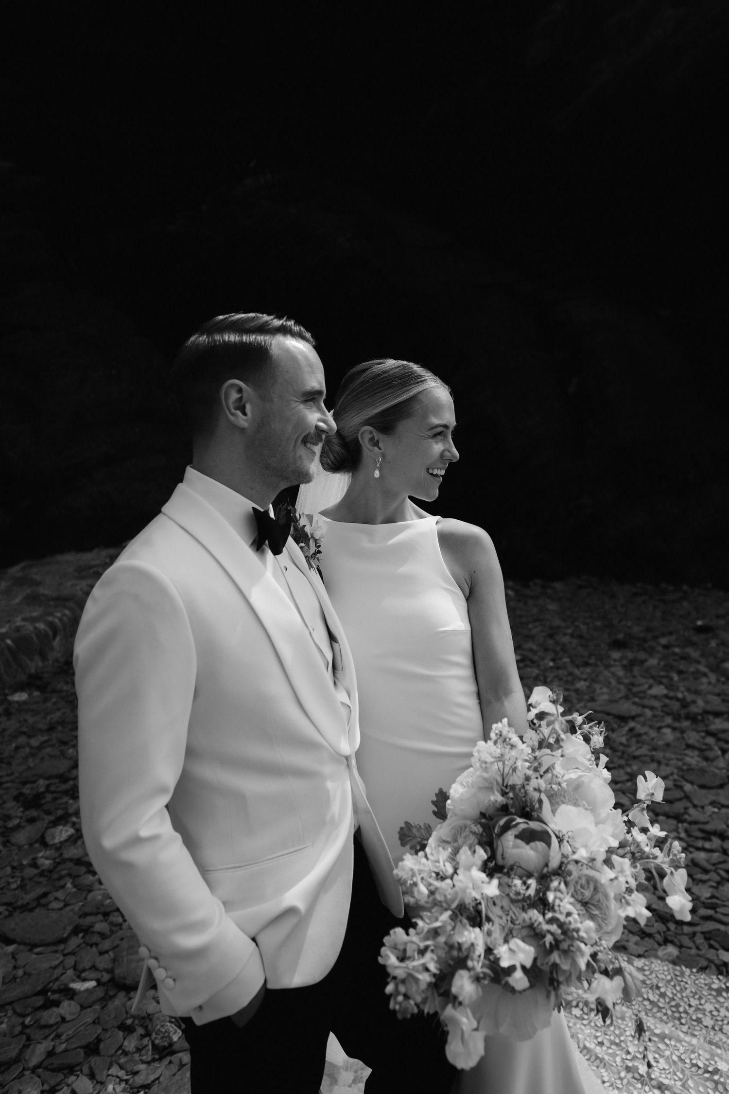 bride and groom against cliff face at tunnels beach in ilfracombe