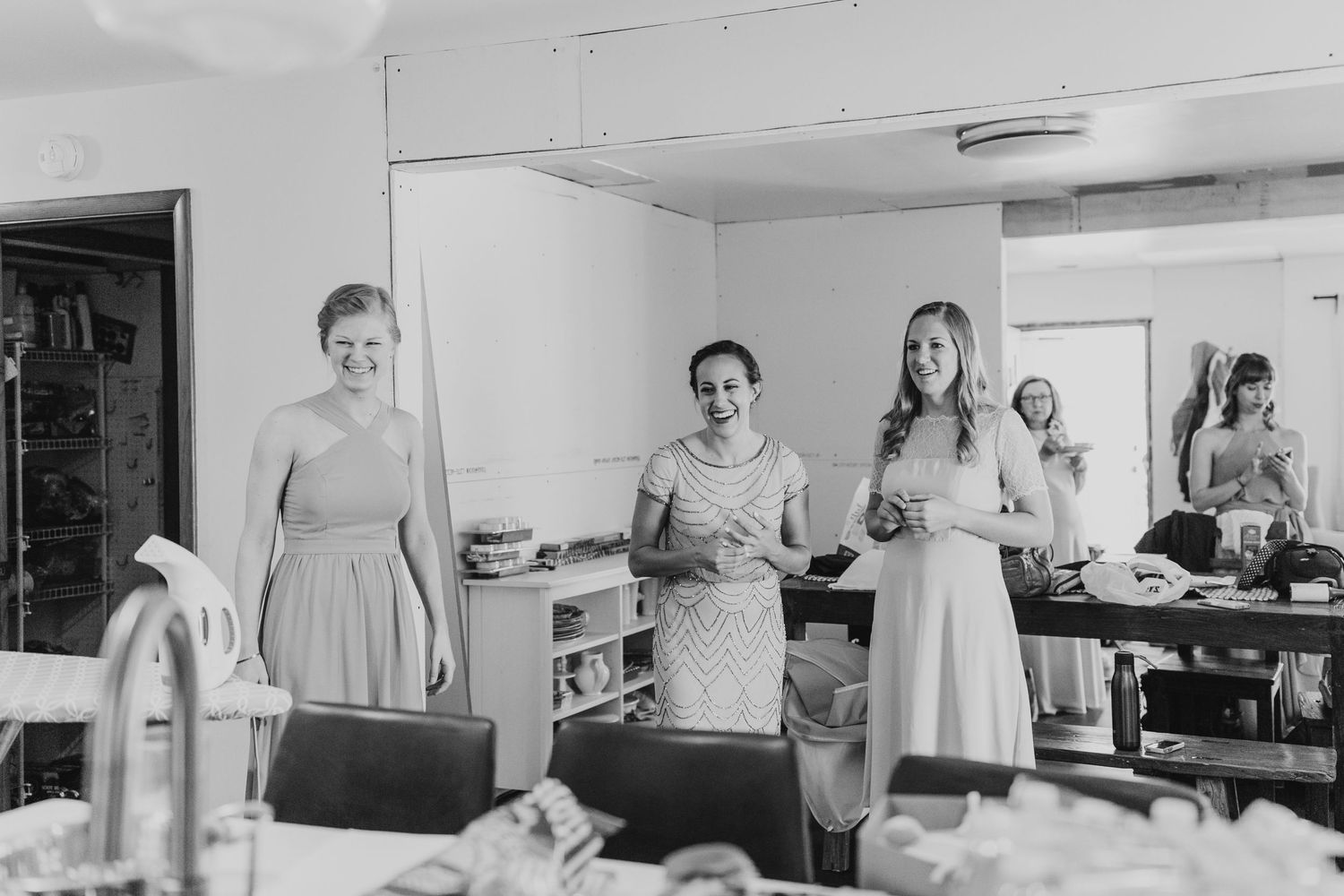 Black and white photo of wedding party members getting ready in a dressing room.