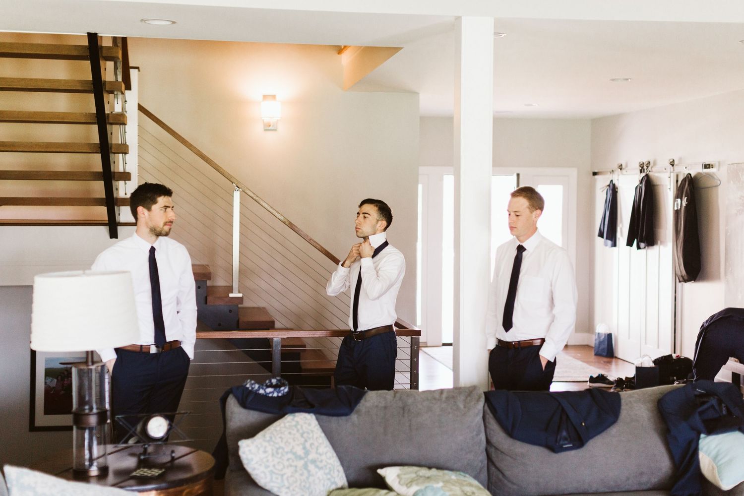Wedding party getting ready in a bright modern room with white decor.