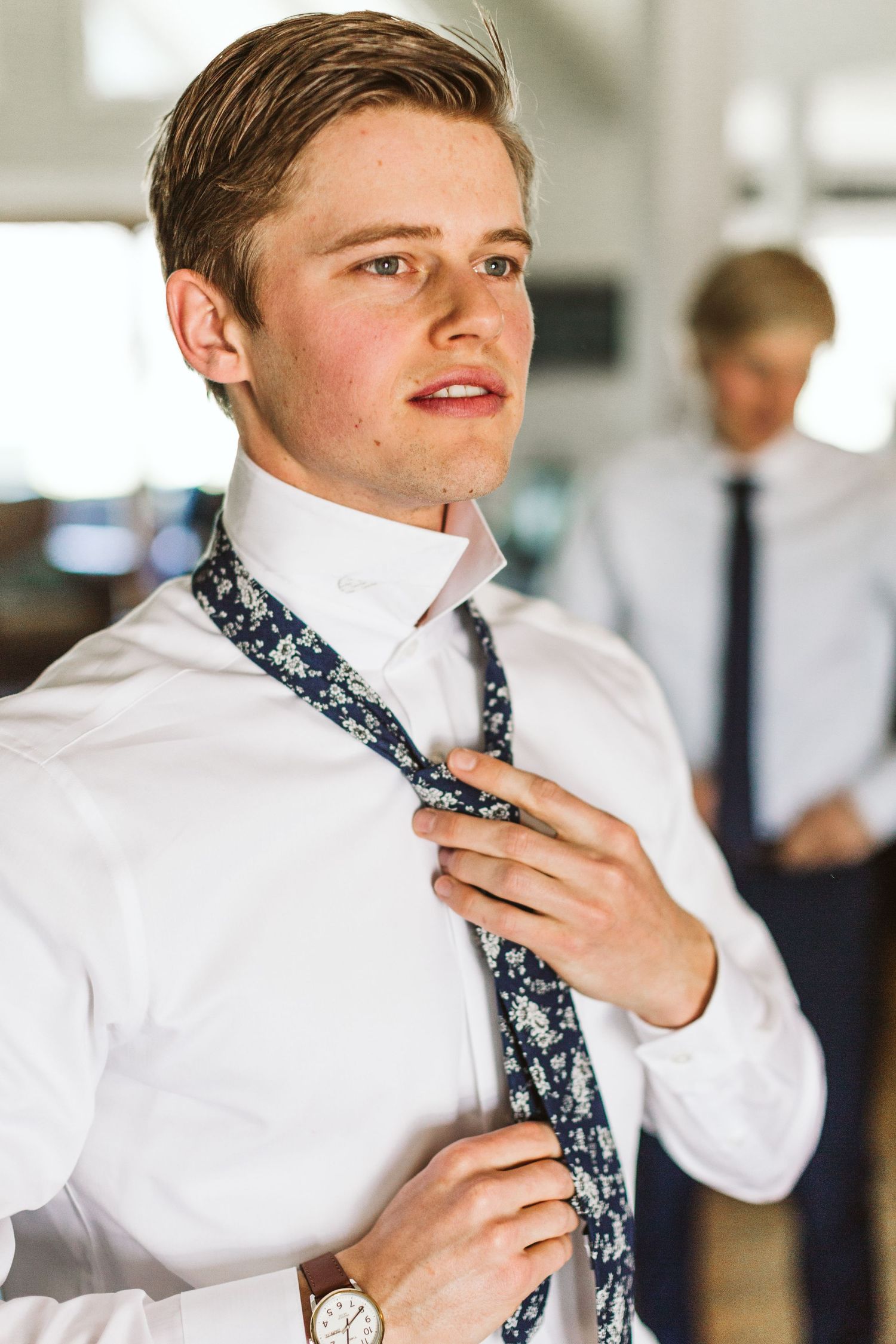 Formal preparation scene with floral patterned navy tie and crisp white shirt.