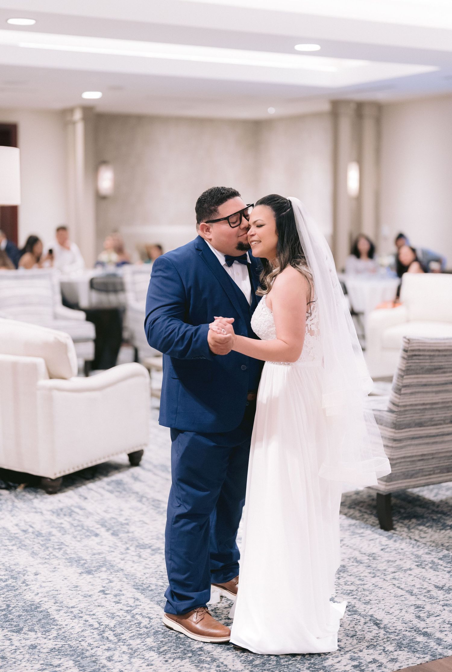 Bride and groom sharing a romantic embrace during an indoor wedding reception