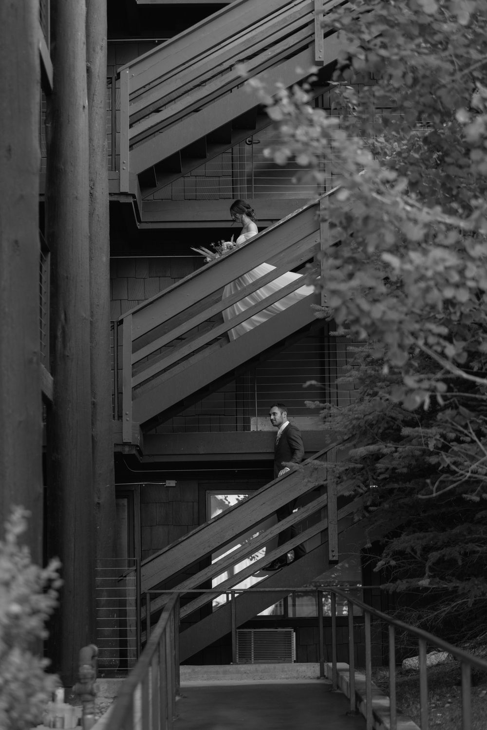 A black and white architectural photograph shows a geometric pattern of outdoor staircases and railings on a building.