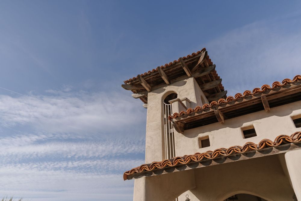 Mediterranean-style luxury villa with terracotta roof tiles and white stucco exterior showcases elegant architectural details.
