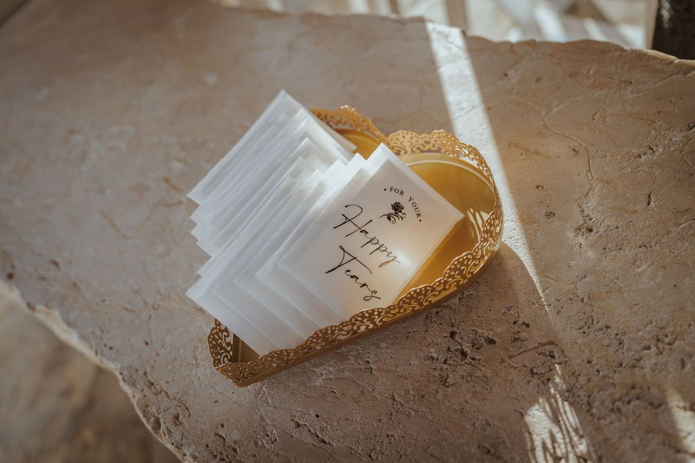 White paint brush with bristles resting on a textured brown surface with speckled paint marks.