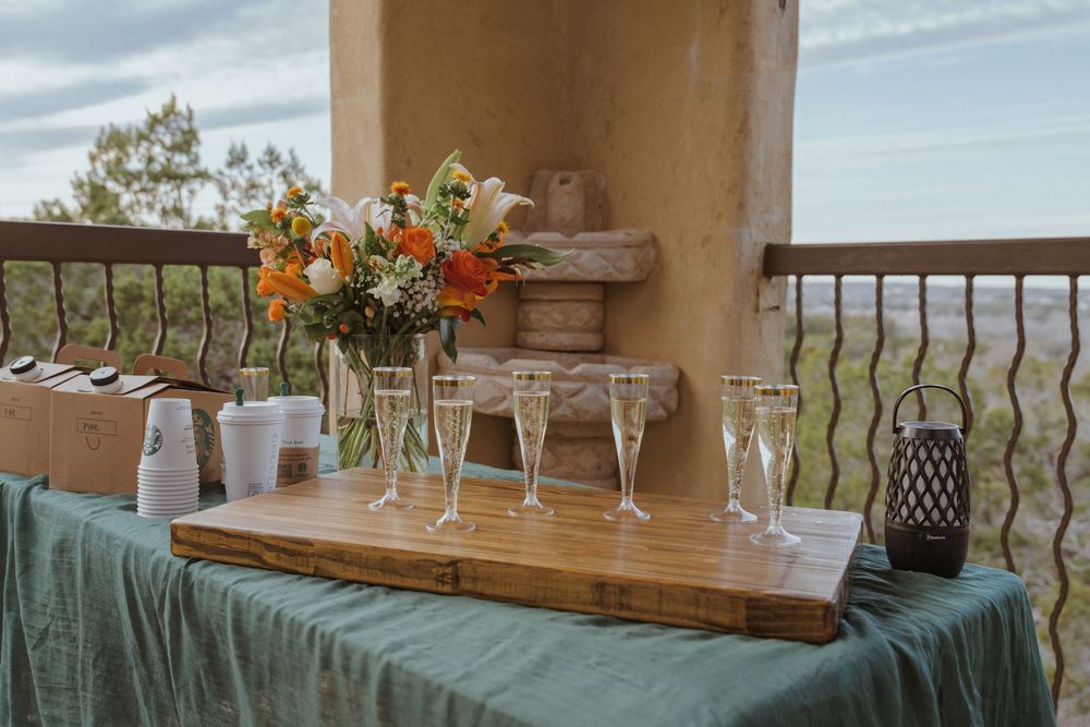 Wedding reception tables decorated with floral centerpieces and rustic decor in an elegant outdoor venue setting.