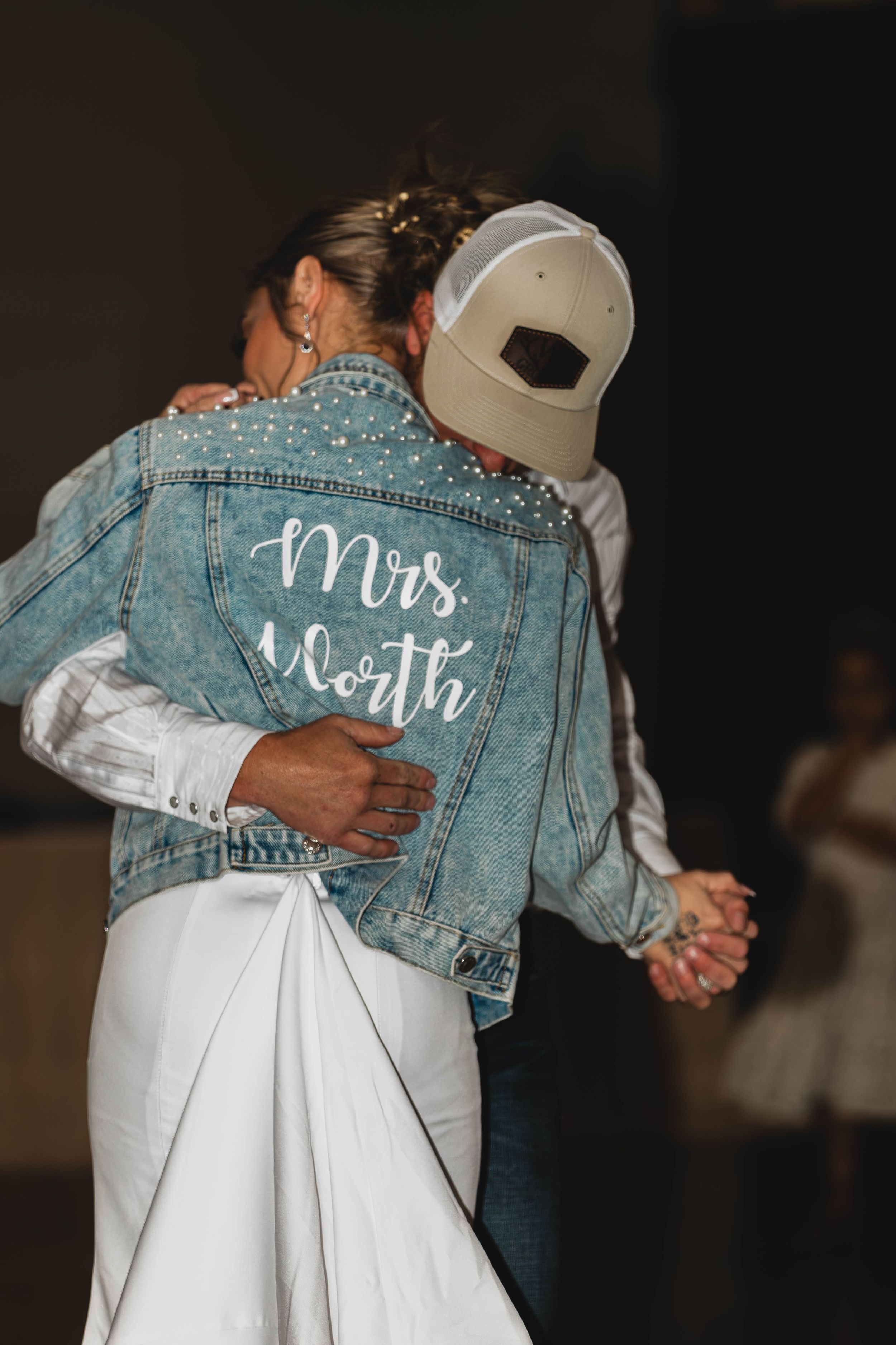 Couple dancing while bride wears custom denim jacket with 'Mrs. North' text.