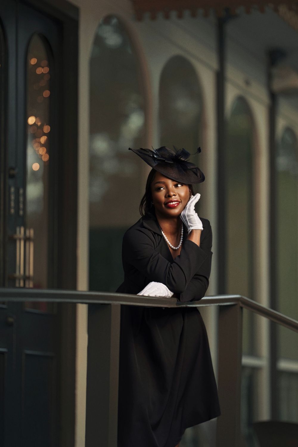 A series of elegant photos showing someone in vintage-inspired attire with a black hat and white gloves against an arched hallway.