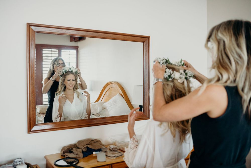 A series of mirror reflections showing a person styling blonde hair in a white room.