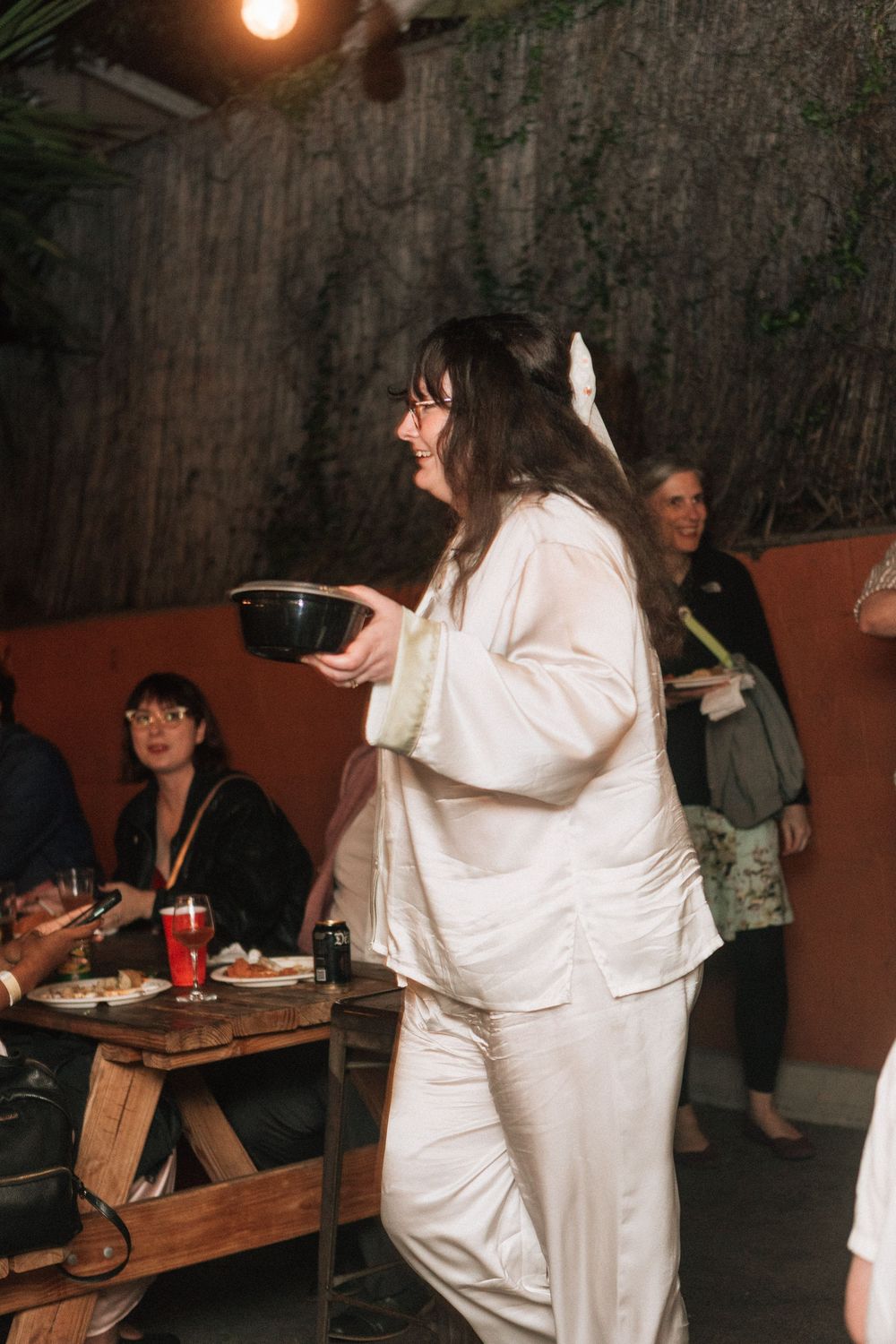 Bride serves guests food at her wedding reception in Los Angeles.