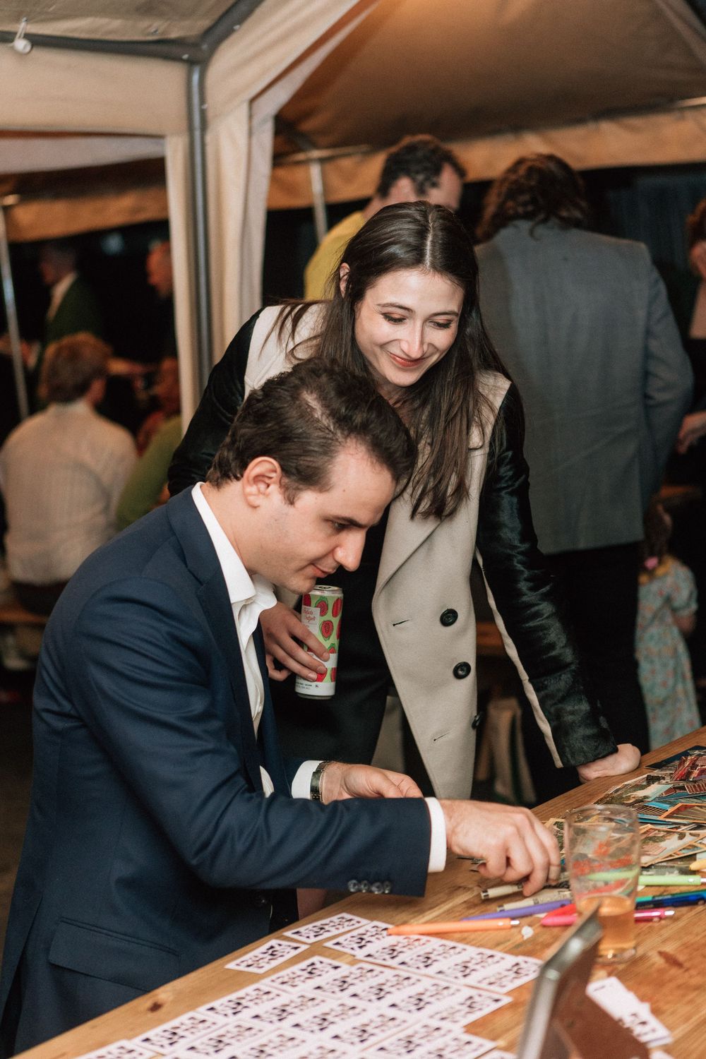 Guests sign guest book and smile for photographer at Los Angeles wedding.