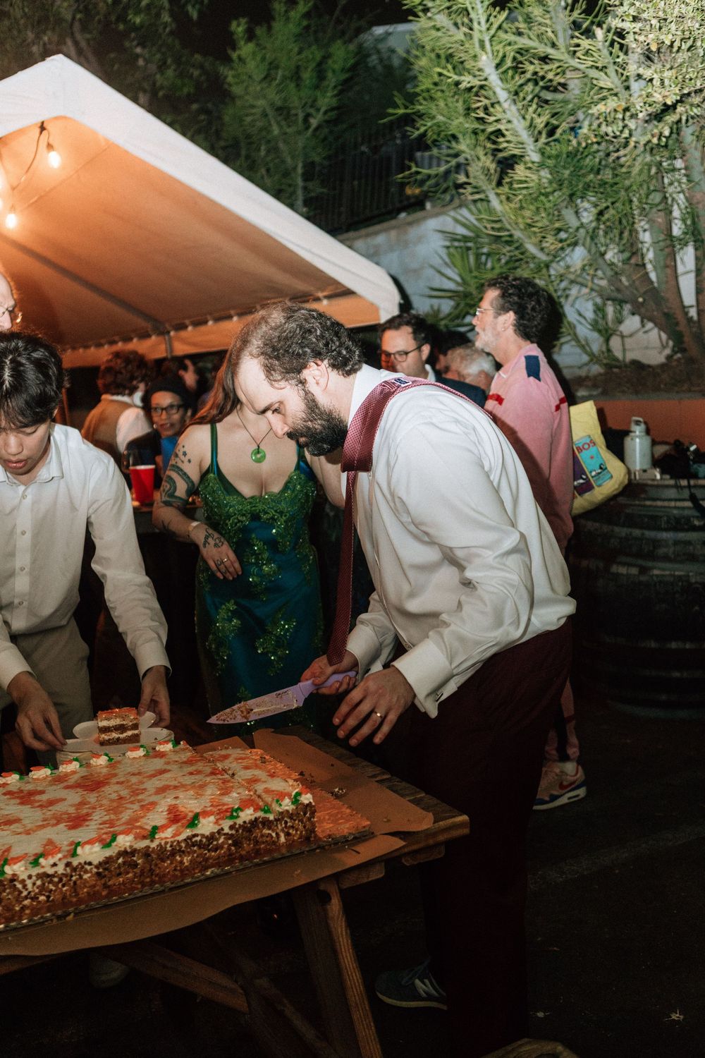 Groom serves cake at Highland Park brewery for his wedding reception.