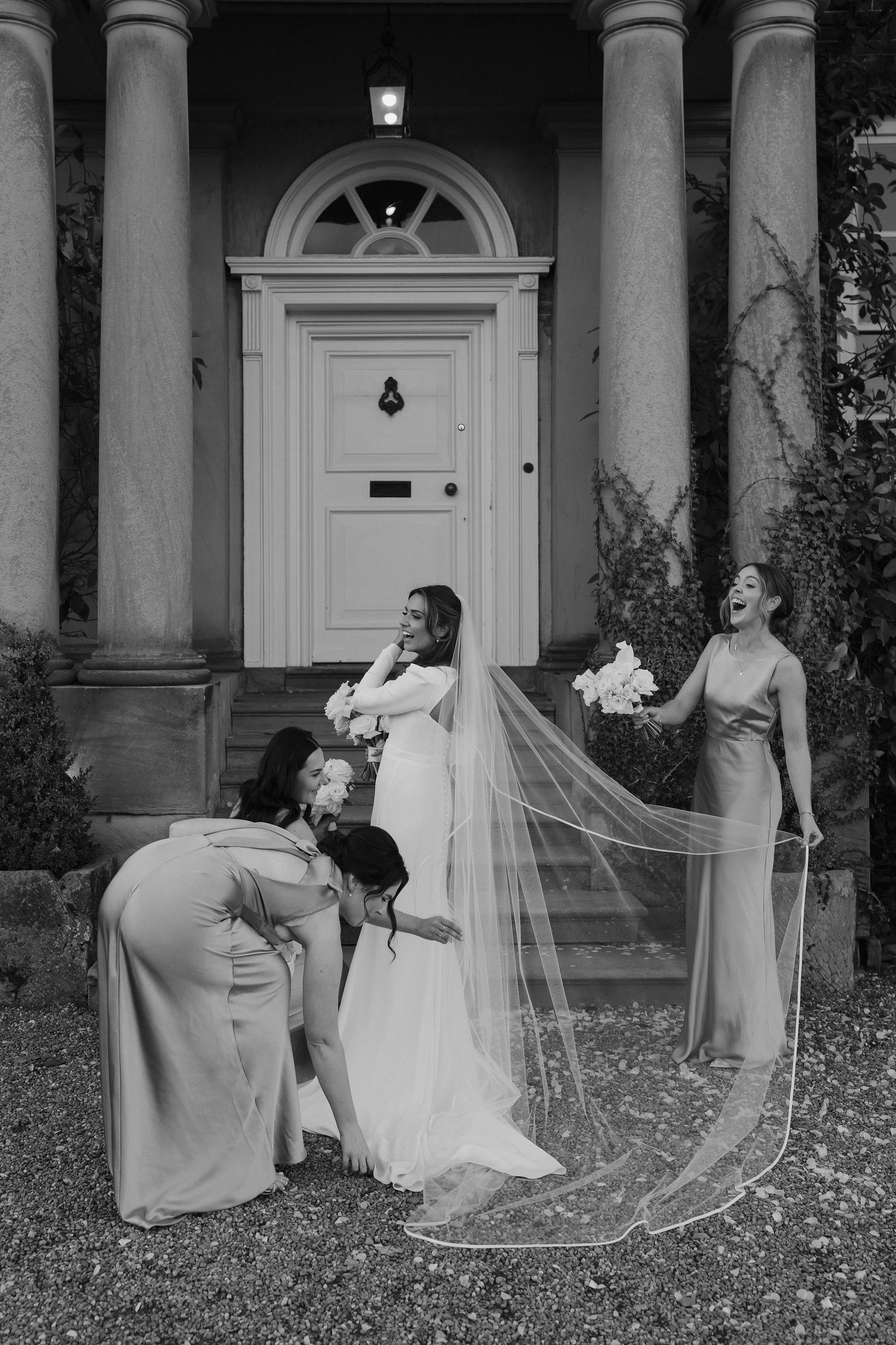 bridesmaids helping bride with her dress outside Iscoyd park
