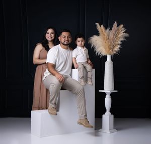 Modern family portrait session with white decorative elements on dark background.