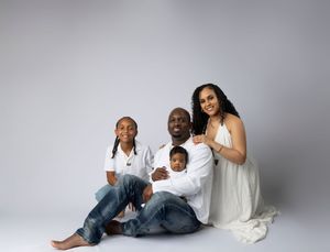 Relaxed family portrait series in coordinated white and denim outfits against grey background.