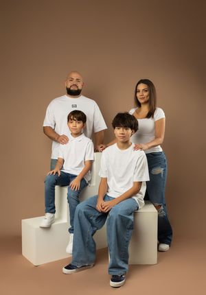 Family lifestyle portraits in matching white t-shirts and jeans on brown background.