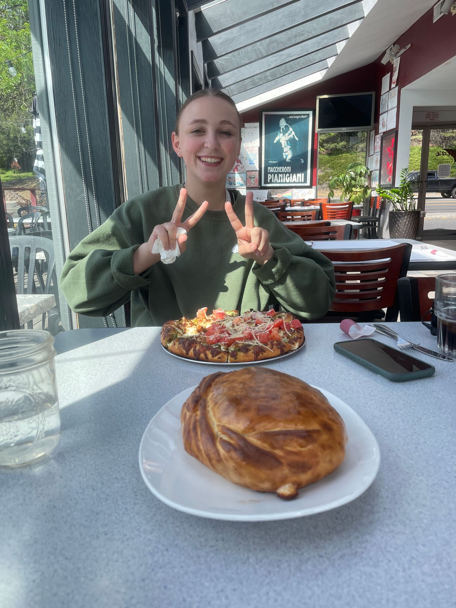 A diner guest makes peace signs over their meal at a casual restaurant.