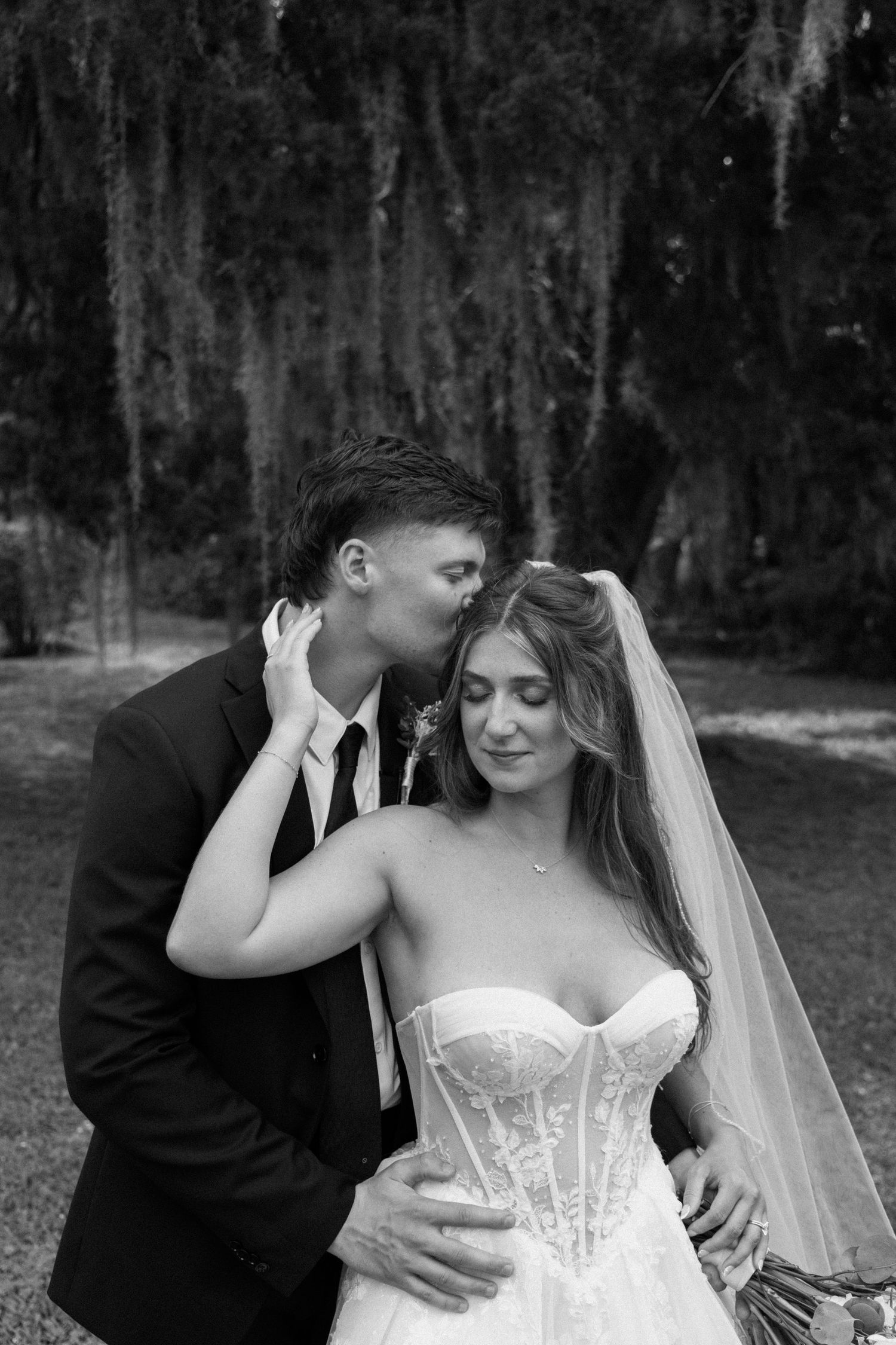 A romantic black and white wedding photo sequence showing tender moments between newlyweds in a forest setting.