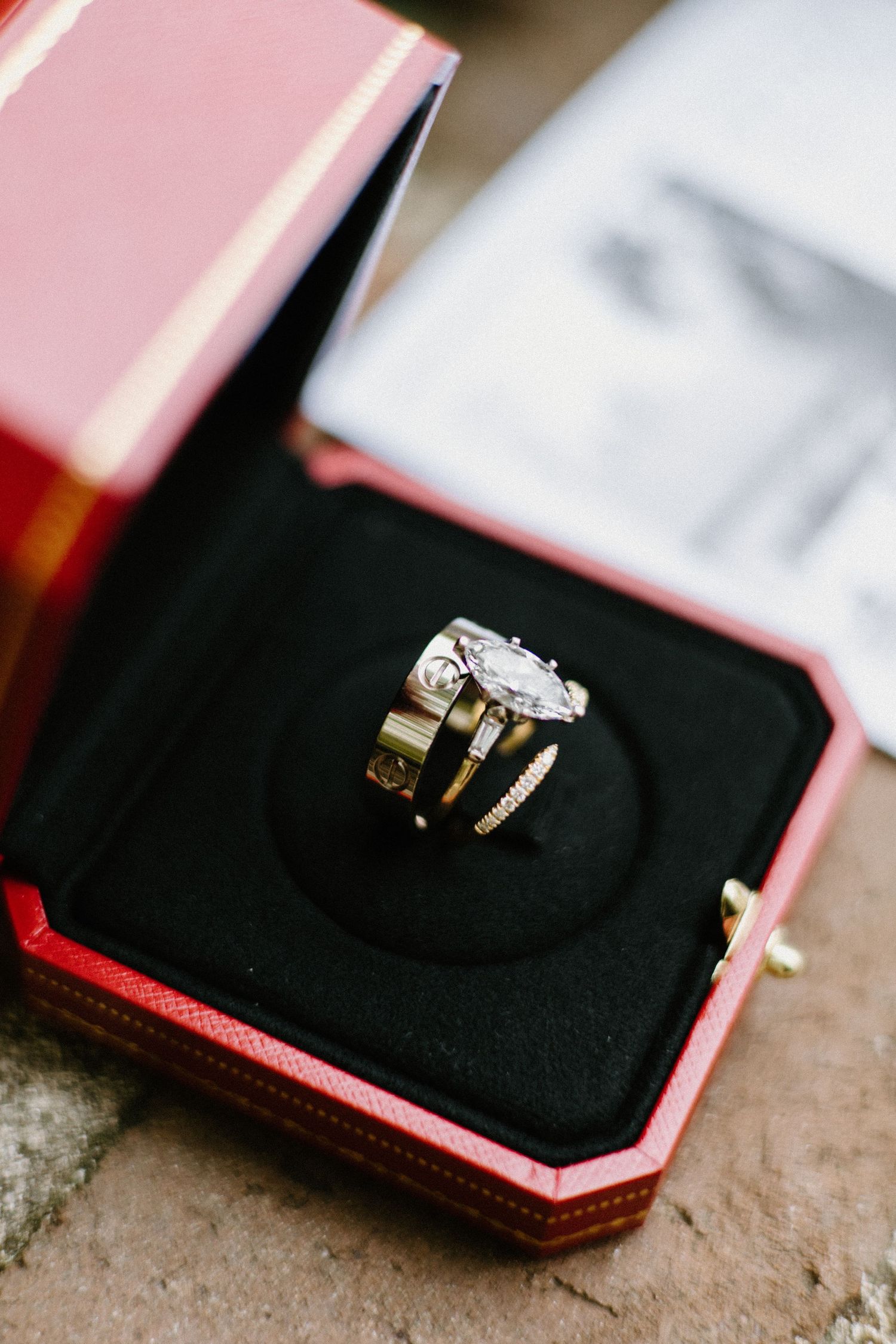 Elegant diamond engagement ring nestled in a black velvet box with pink packaging.