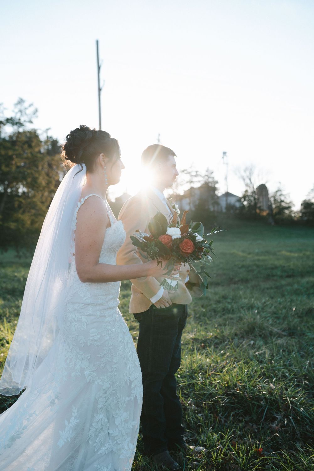 Romantic outdoor wedding photos showing bride and groom in a sunlit field at golden hour.