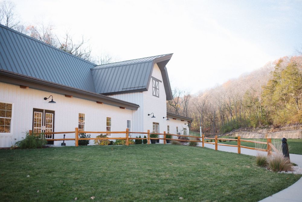 Exterior view of a white modern farmhouse style wedding venue with metal roof.