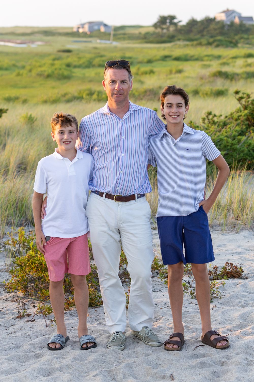 A father and sons pose together  at the Wauwinet hotel on Nantucket, MA at sunset by Lisa West Photography www.lisawestphotography.com