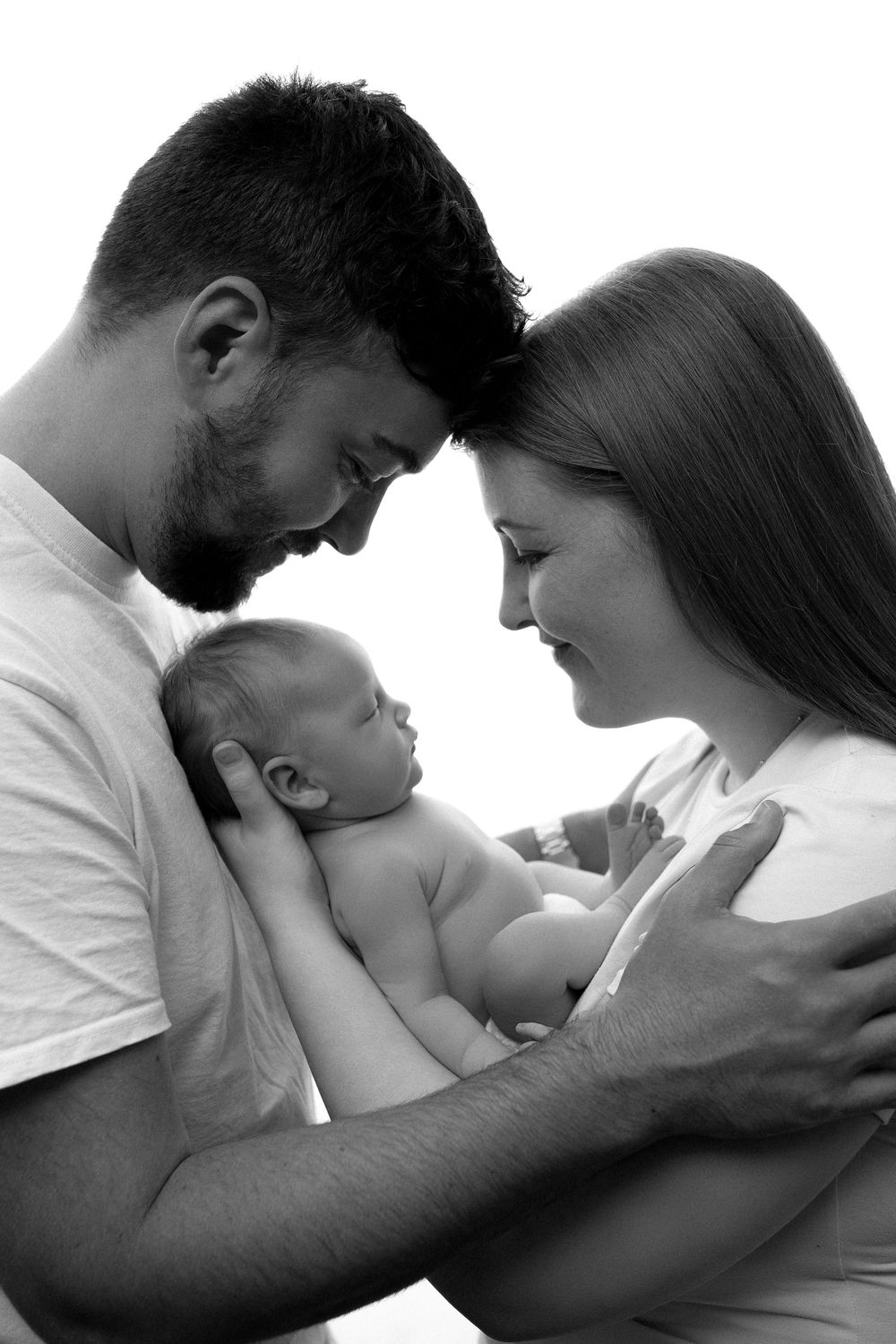 A sequence of intimate black and white photos showing tender moments between parent and infant in profile.