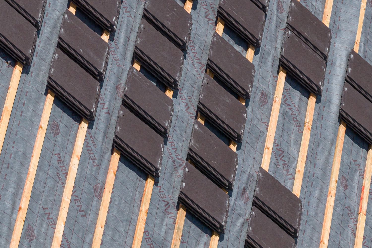 Multiple roof panels photographed against sunlight creating dramatic parallel lines and shadows.