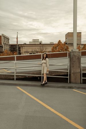 A sequence of photos shows someone sitting on a railing of a parking garage at sunset with an urban backdrop.