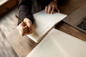 A person's hand writes with a pencil on white paper in a sequence of seven similar images.